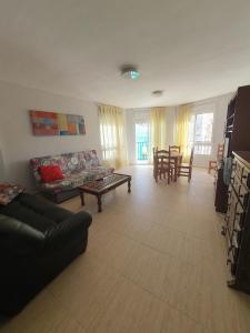 アルカラ・デ・チベルトにあるApartamento para 5 personas en Alcalá de Xivertのソファとテーブルのあるリビングルーム
