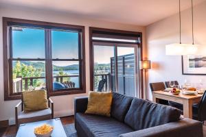 a living room with a couch and a table at Lakefront, Mountain View - Resort Loft in Lac-Superieur
