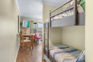 Un dormitorio con una litera y un escritorio. en Grand Caribbean East, beach view, nearby beach access, en Destin 26 fotos más