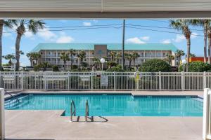 Una piscina con dos tablas de surf frente a un resort. en Grand Caribbean East, beach view, nearby beach access, en Destin