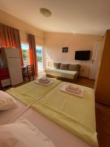 a bedroom with two beds and a couch and a television at Apartments Villa-G Lustica in Tivat