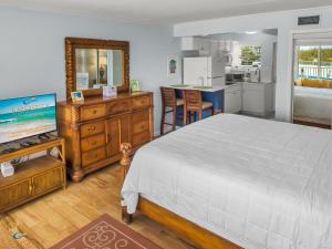 a bedroom with a large bed and a kitchen at Cozy Studio Beachfront Condo - Romantic Getaway! in Fort Walton Beach