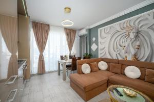 a living room with a brown couch and a table at V&T Residence Mamaia Nord in Mamaia Sat/Năvodari