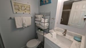 a bathroom with a toilet and a sink and a mirror at Cozy Studio Beachfront Condo - Romantic Getaway! in Fort Walton Beach +36 photos