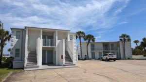 a white house with a car parked in front of it at Cozy Studio Beachfront Condo - Romantic Getaway! in Fort Walton Beach