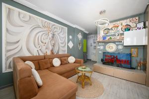 a living room with a couch and a tv at V&T Residence Mamaia Nord in Mamaia Sat/Năvodari