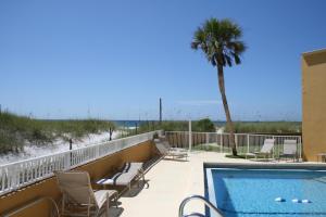 a balcony with a swimming pool and a palm tree at IS2 - Cozy 1 Bd - Steps Away From the Beach in Fort Walton Beach