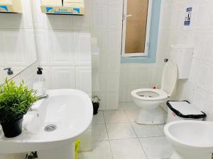 Un baño blanco con inodoro y lavabo. en Kuti Hostel, en Lisboa