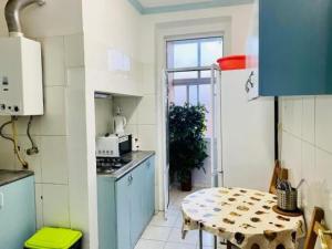 cocina con mesa y cocina con microondas en Kuti Hostel, en Lisboa