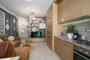a kitchen and living room with a couch and a table at V&T Residence Mamaia Nord in Mamaia Sat/Năvodari