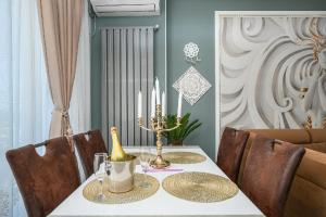 a dining room with a table with a bottle and candles at V&T Residence Mamaia Nord in Mamaia Sat/Năvodari +32 photos