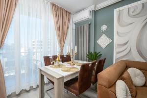 a dining room with a table and a couch at V&T Residence Mamaia Nord in Mamaia Sat/Năvodari