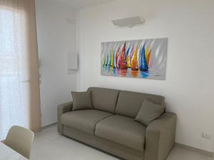 a living room with a couch and a painting on the wall at Casa LE VELE in Torre Pali