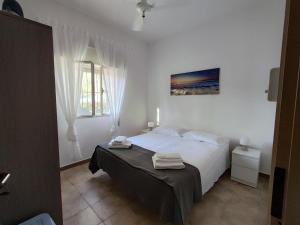 a white bedroom with a bed and a window at Villa d'Angela in San Pietro in Bevagna