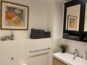 伦敦Lombok Apartment near Old Street,Islington,Angel的带水槽和镜子的白色浴室