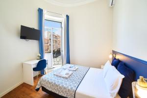 a hotel room with a bed and a window at Baron Faro - Guest House in Faro