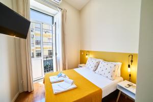 Una habitación de hotel con una cama y una ventana grande. en Baron Faro - Guest House, en Faro