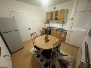 a kitchen with a table and chairs and a refrigerator at The Great Escape in Bitola +6 photos