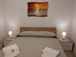 - une chambre avec un lit avec deux lampes et un tableau mural dans l'établissement La Casa di Ary alle pendici dell'Etna, à Nicolosi