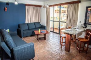 a living room with a blue couch and a table at Hotel Puerto Playa Suites in El Morro de Barcelona