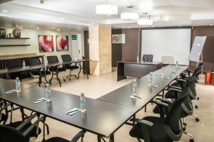 a conference room with tables and chairs and a whiteboard at Hotel Puerto Playa Suites in El Morro de Barcelona