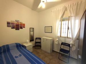 a bedroom with a bed and two chairs and a window at Villa d'Angela in San Pietro in Bevagna