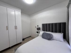 a bedroom with a large white bed with a black headboard at Siena Sun 09 in Midrand