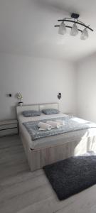 a bed in a white room with a bed sidx sidx sidx at Andira Residence in Sibiu