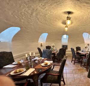 a dining room with tables and chairs and a ceiling at Hotel Møllehuset til Visborggaard Slot in Hadsund
