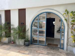 an entrance to a building with a blue door and plants at Hostal 53 Boutique Santo Domingo in Santo Domingo