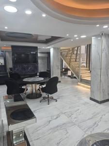 a lobby with a table and chairs and a staircase at La Luna in Bangui