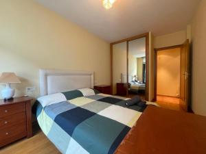 Un dormitorio con una cama, una cómoda y un espejo. en Apartamento en Ribeira a 200m de la playa, en Ribeira