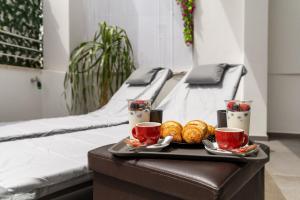 a tray of food on a table with two beds at Le Suite di Magda Relax & Rooms in Polignano a Mare