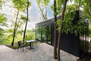 a house with a table and chairs on a patio at Tree House Relax Park in Chişinău