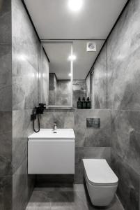 a bathroom with a white sink and a toilet at Tree House Relax Park in Chişinău