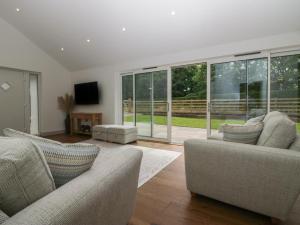 a living room with two couches and a large window at Heather's Cottage in Carlisle