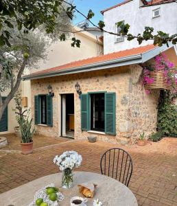 a table in front of a building with green shutters at Merian's House in Fethiye