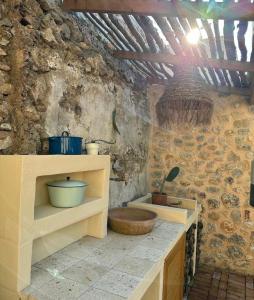 a kitchen with a stone wall with a wooden sink at Merian's House in Fethiye