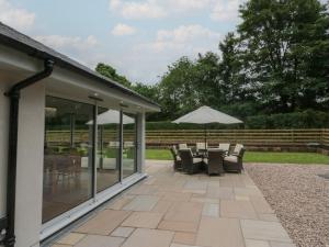 a patio with a table and chairs and an umbrella at Heather's Cottage in Carlisle