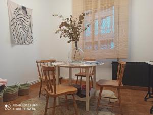 a dining room table with a vase with flowers in it at Villa Caamaño in Gijón