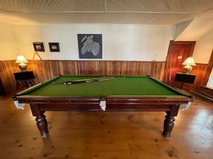 a green pool table in a room with two lamps at Family Cottage Sheep Island in Delta