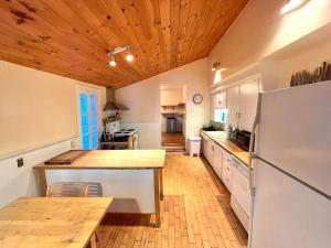 a kitchen with a refrigerator and a table in it at Family Cottage Sheep Island in Delta