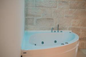 a bath tub in a bathroom with a brick wall at Relais La Muraglia - Central Luxury Rooms - Molfetta in Molfetta
