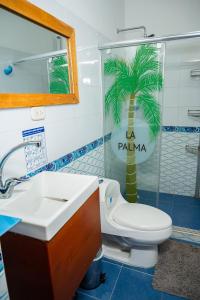 a bathroom with a toilet and a palm tree sign at Hotel La Palma Centro Histórico in Santa Marta +34 photos