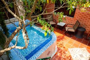 a swimming pool with two chairs and a tree at Hotel La Palma Centro Histórico in Santa Marta