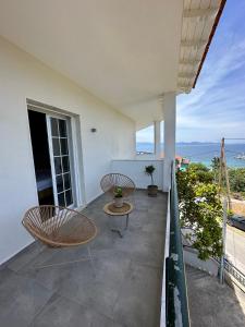 a balcony with two chairs and a table at Villa Eleni Greece - wonderful sea view studios in Nea Roda