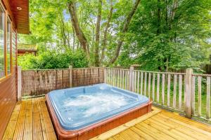 a hot tub sitting on the deck of a house at Blenheim Lodge 21 in Kingham