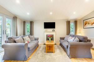 a living room with two couches and a tv at Blenheim Lodge 21 in Kingham