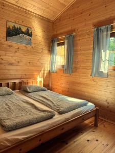 a bedroom with a bed in a wooden cabin at Andiland in Karwia