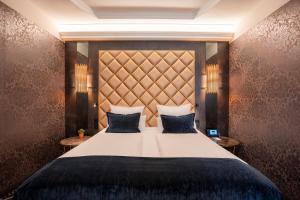 a bedroom with a large bed with blue pillows at Boutique Hotel Germania in Munich